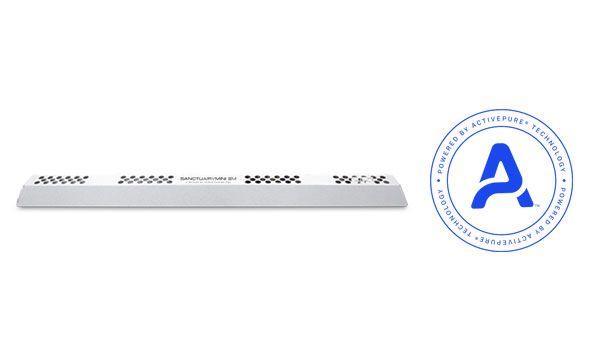 Woman in straw hat smiles, holding wine glass near a lake.