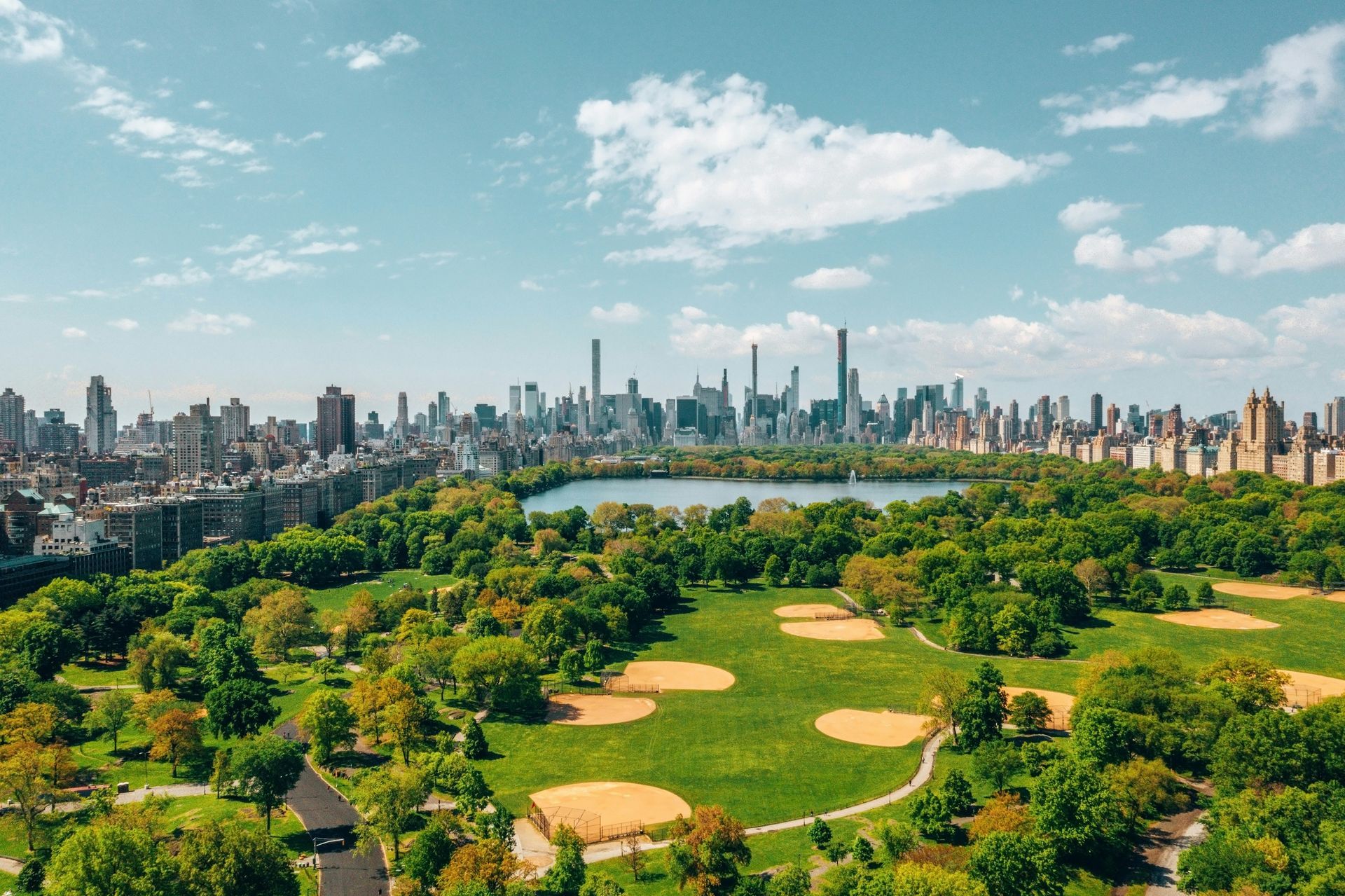 Overhead view of Central Park, NYC, with a skyline in the background and baseball fields.