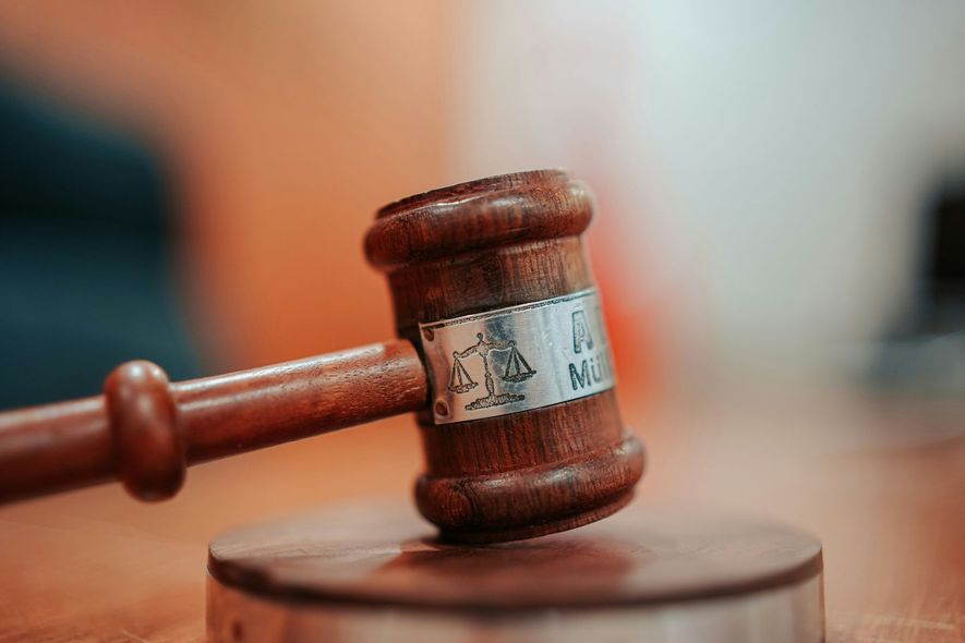 Wooden gavel on a block, on a wooden surface.