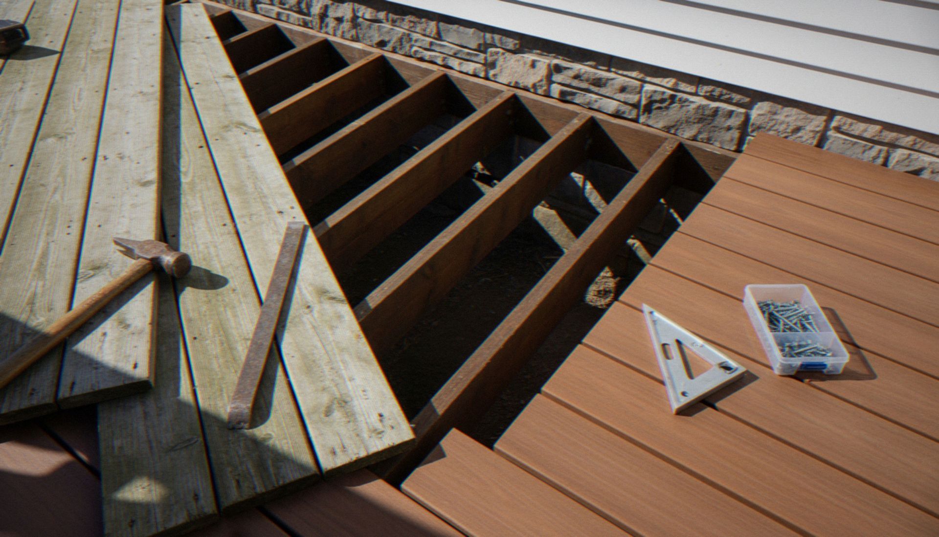 Deck framing under construction with exposed wooden joists, planks, and tools on top