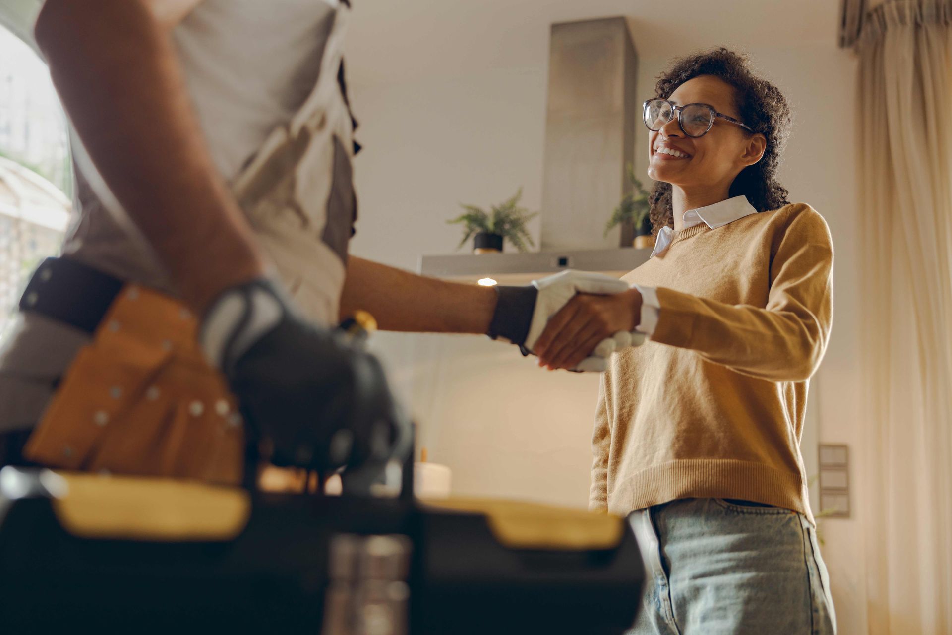 Person handing a box to a smiling delivery worker at the doorway