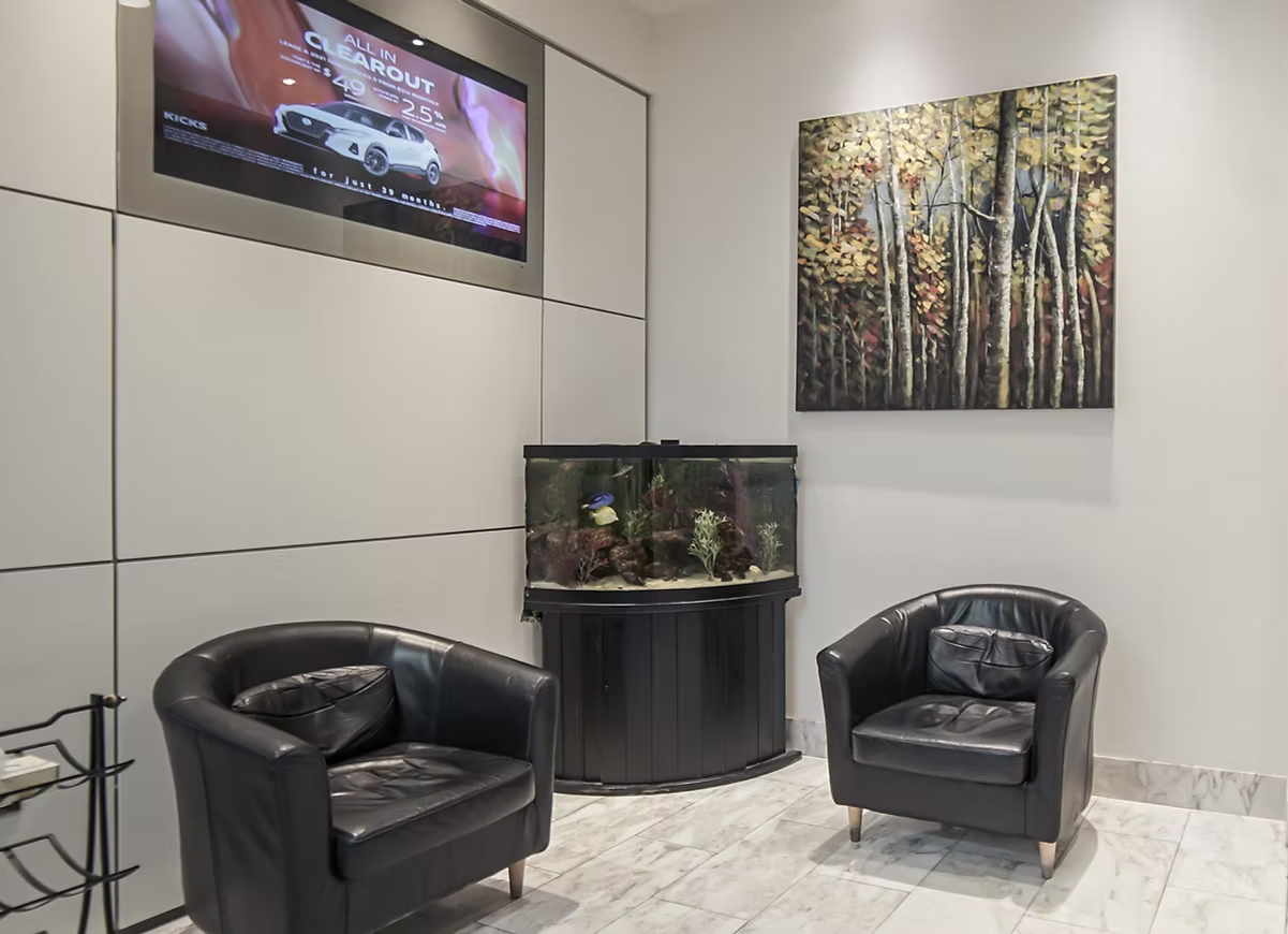 A waiting room with two chairs and an aquarium.