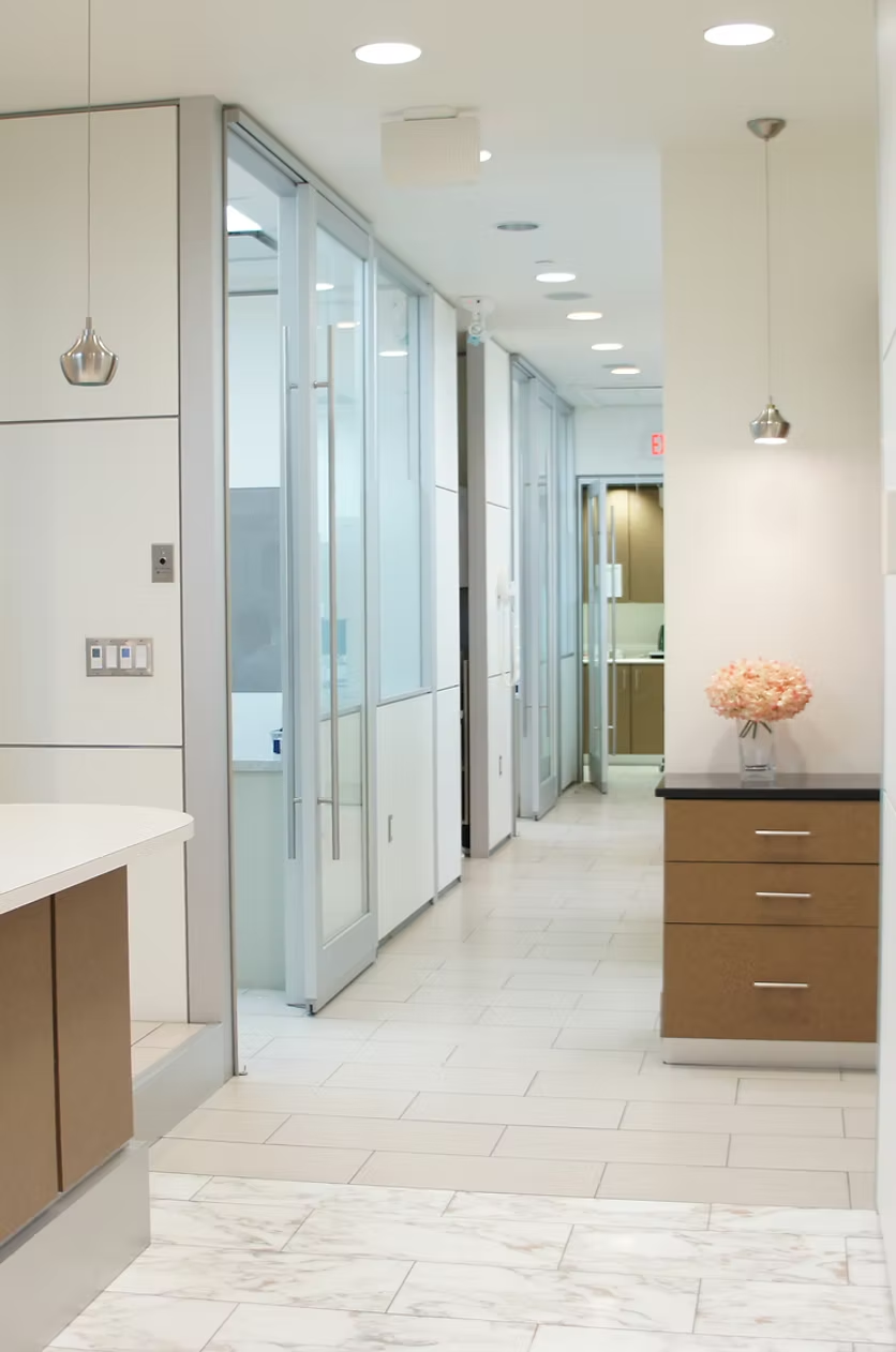 A hallway in a building with a vase of flowers on the counter
