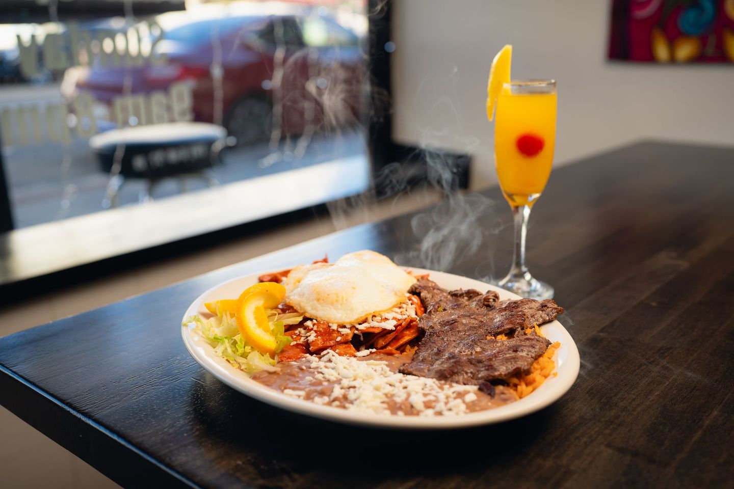 A plate of food and a glass of orange juice on a table.