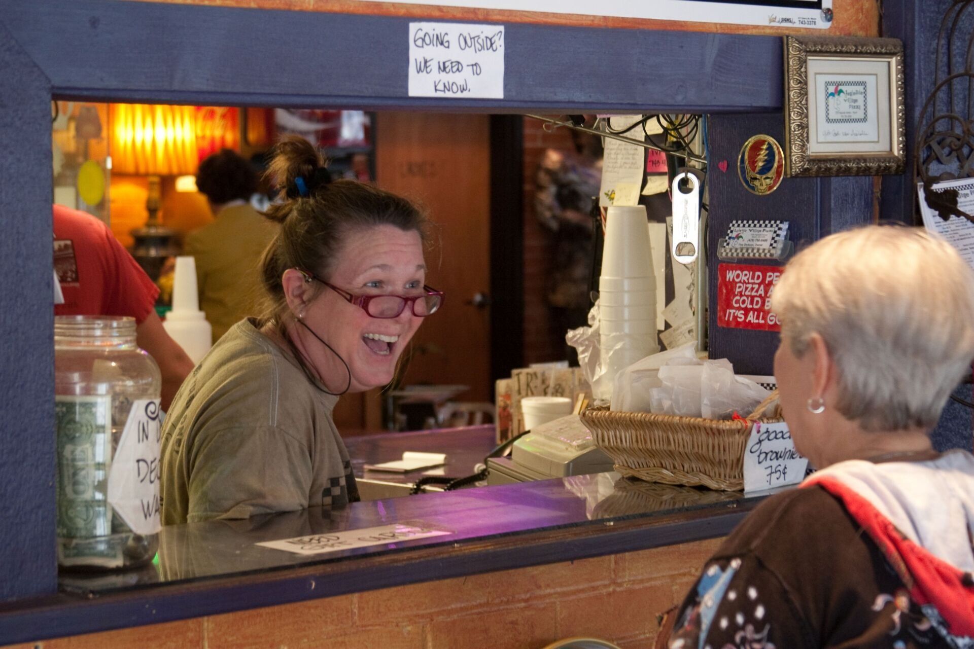 Woman laughing while speaking to other person — Macon, GA — Ingelside Village Pizza