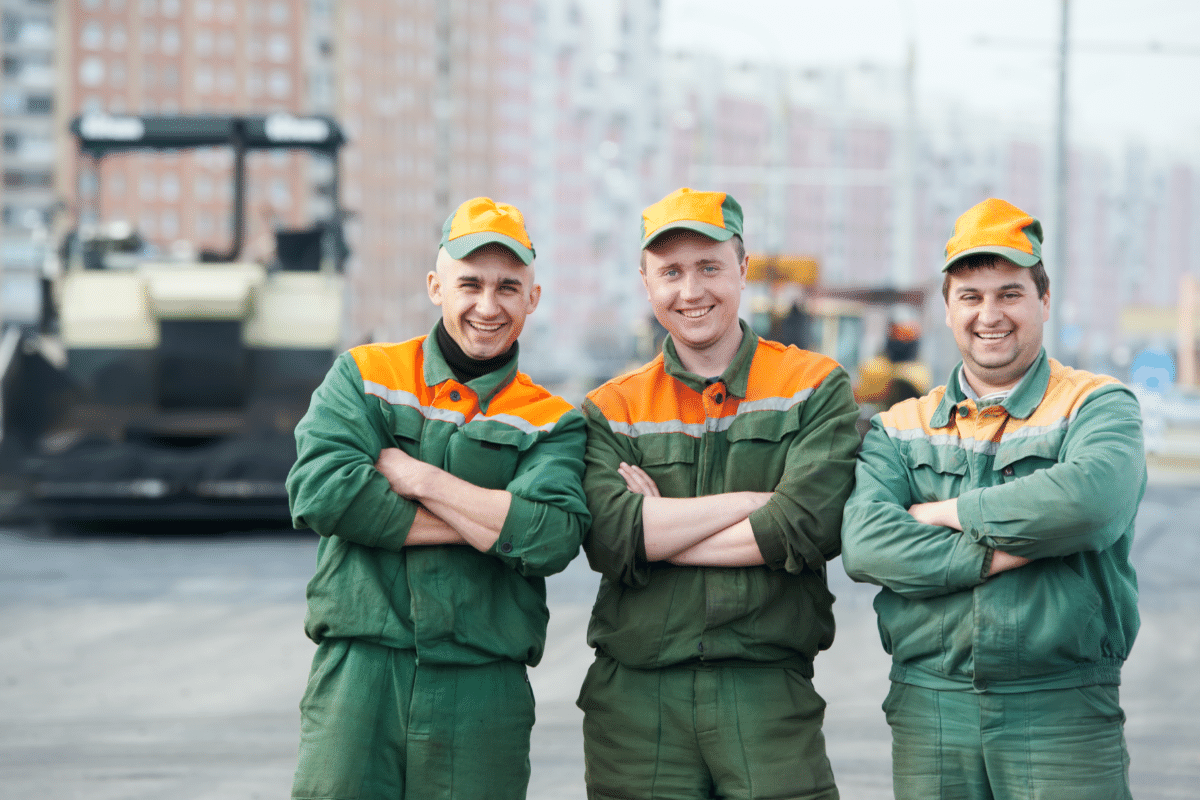 workers in reflective vests using shovels during construction