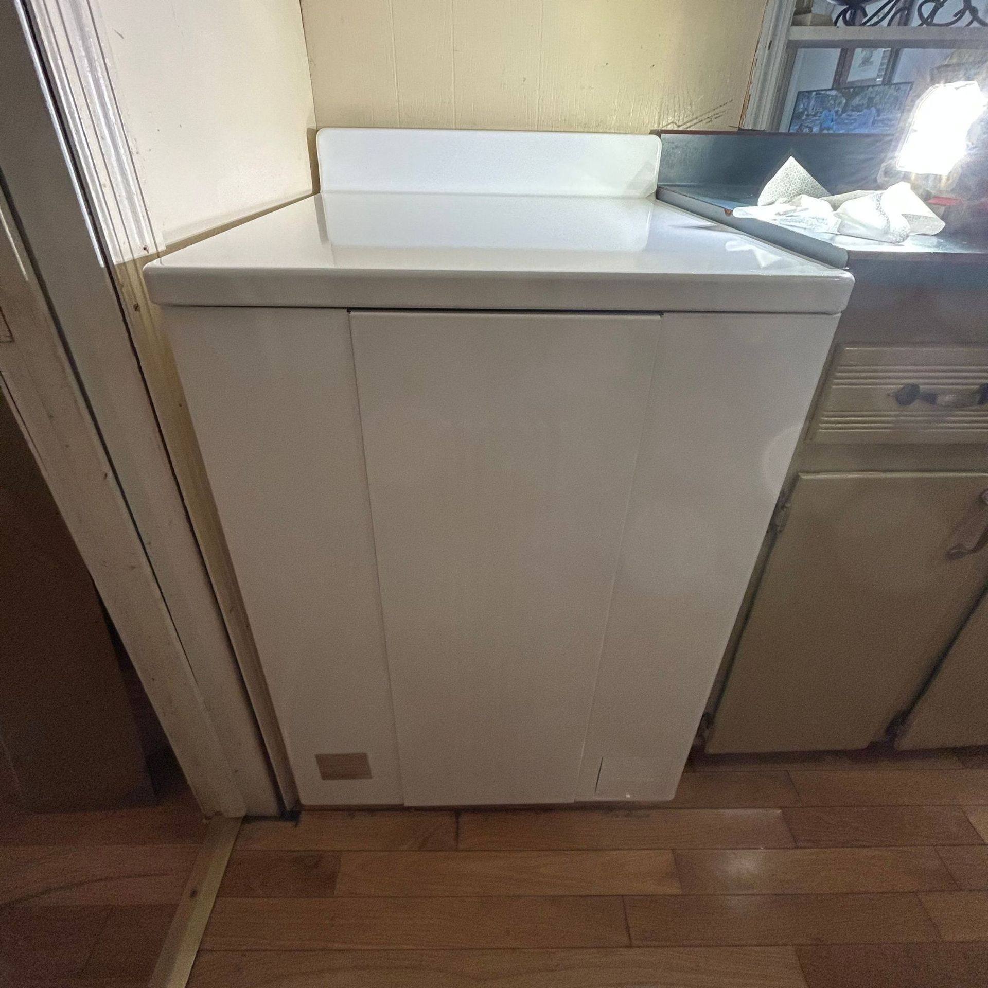 Black River Plumbing & Gas LLC - White washing machine in a kitchen, next to a counter and oven.