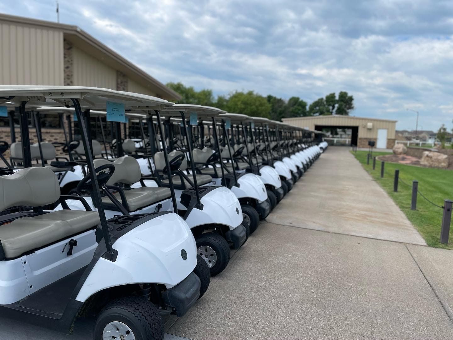 A row of golf carts are parked in front of a building
