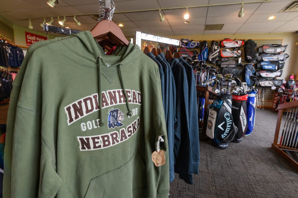 A green indiana golf nebraska hoodie is hanging in a store
