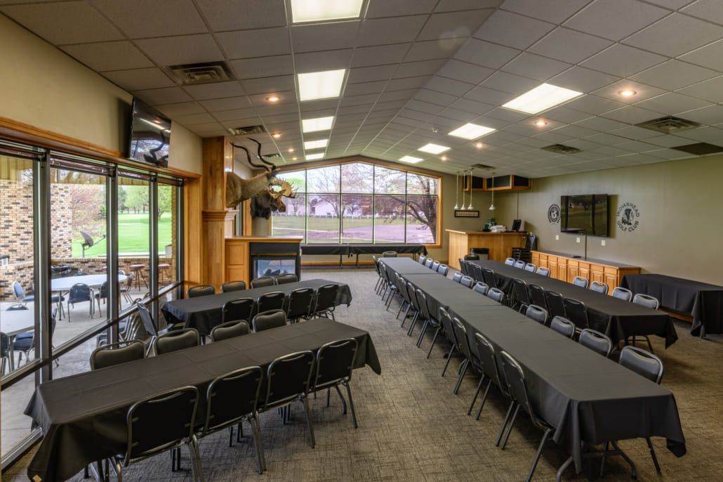 A large room filled with tables and chairs and a fireplace.