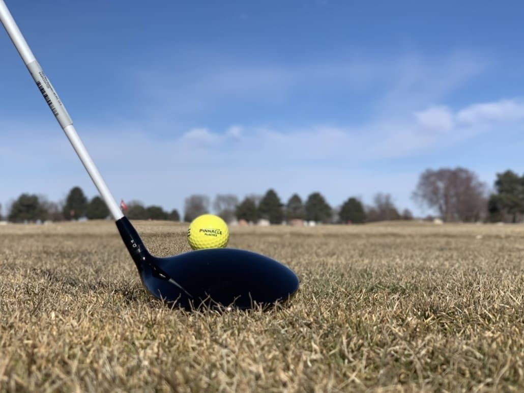A golf club with a golf ball on top of it