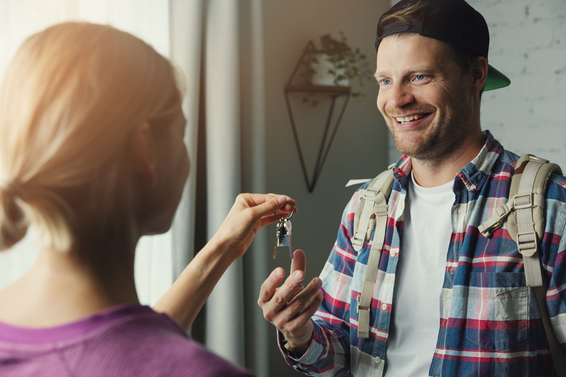 A man is giving a woman a set of keys.