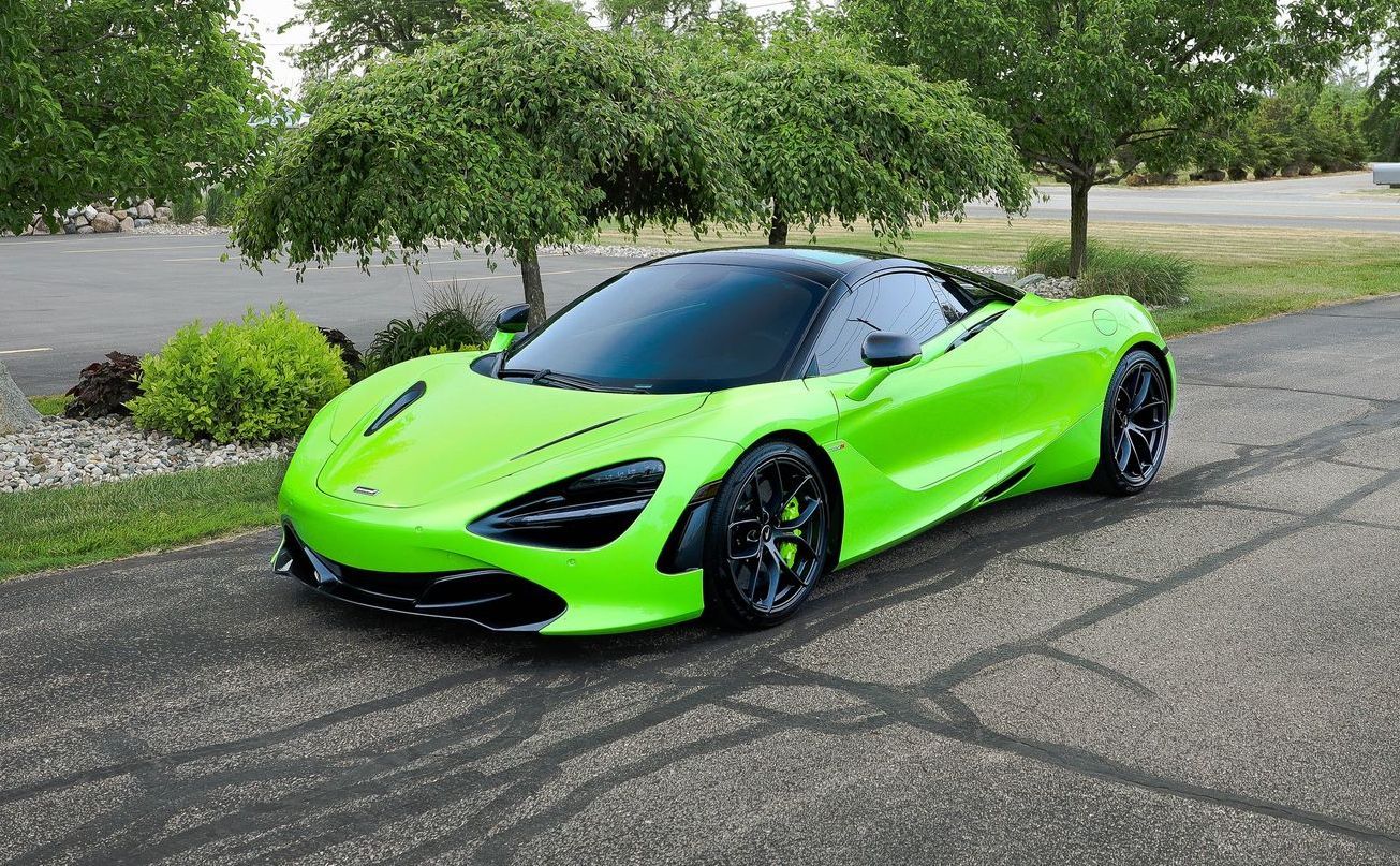 a neon green mclaren 720s is parked on the side of the road .