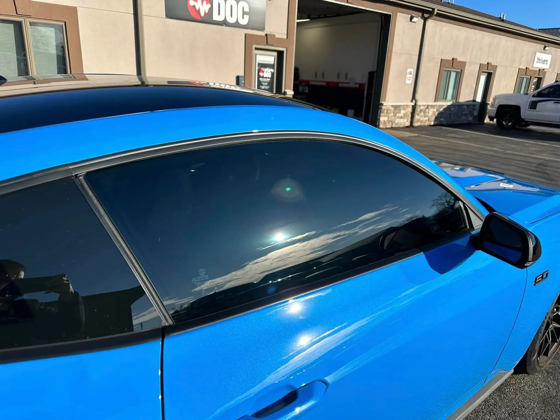 A blue car is parked in front of a building.