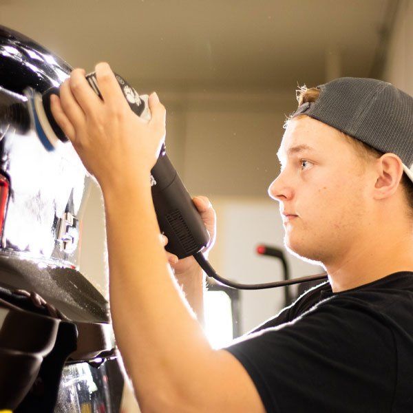 a man is polishing a car with a machine