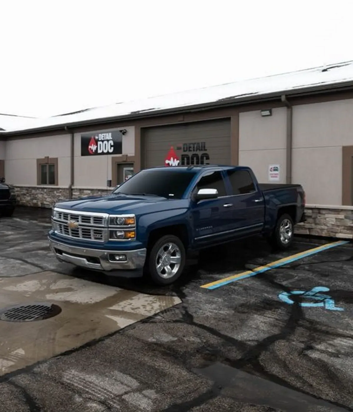 a blue truck is parked in front of a building that says detail doc