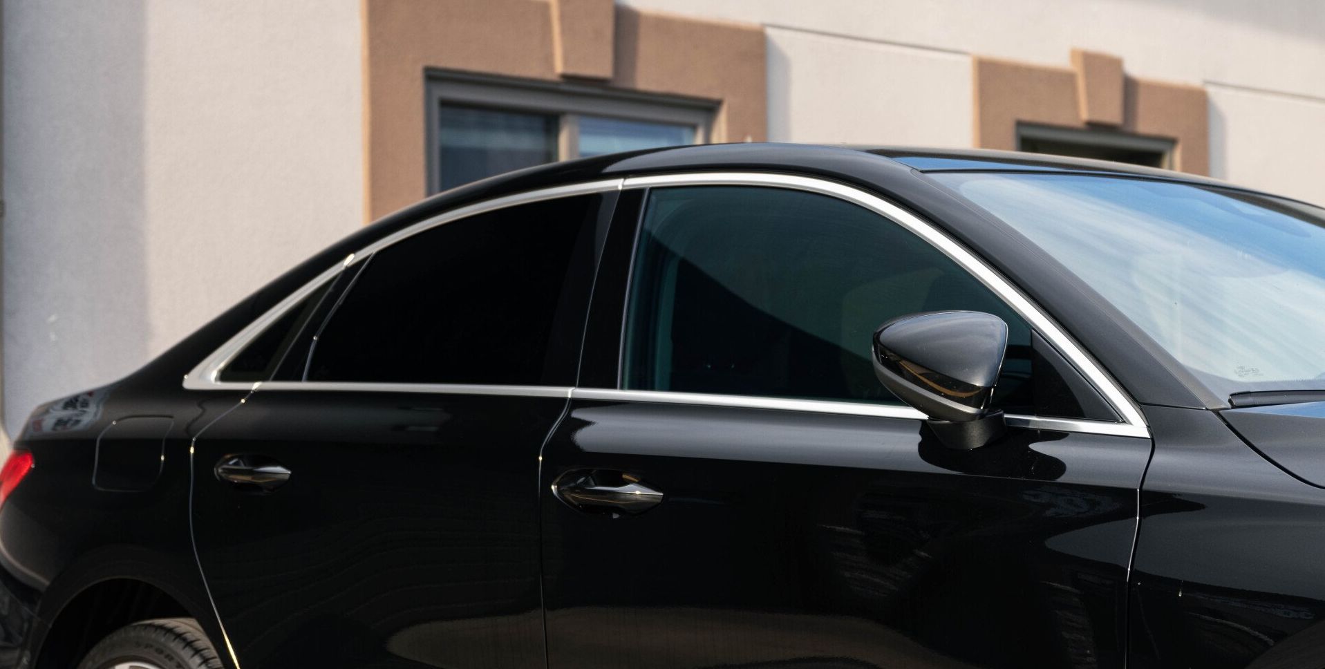 a black car is parked in front of a building .