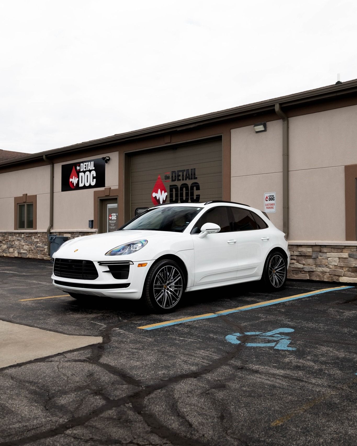 a white porsche macan turbo is parked in front of a building .