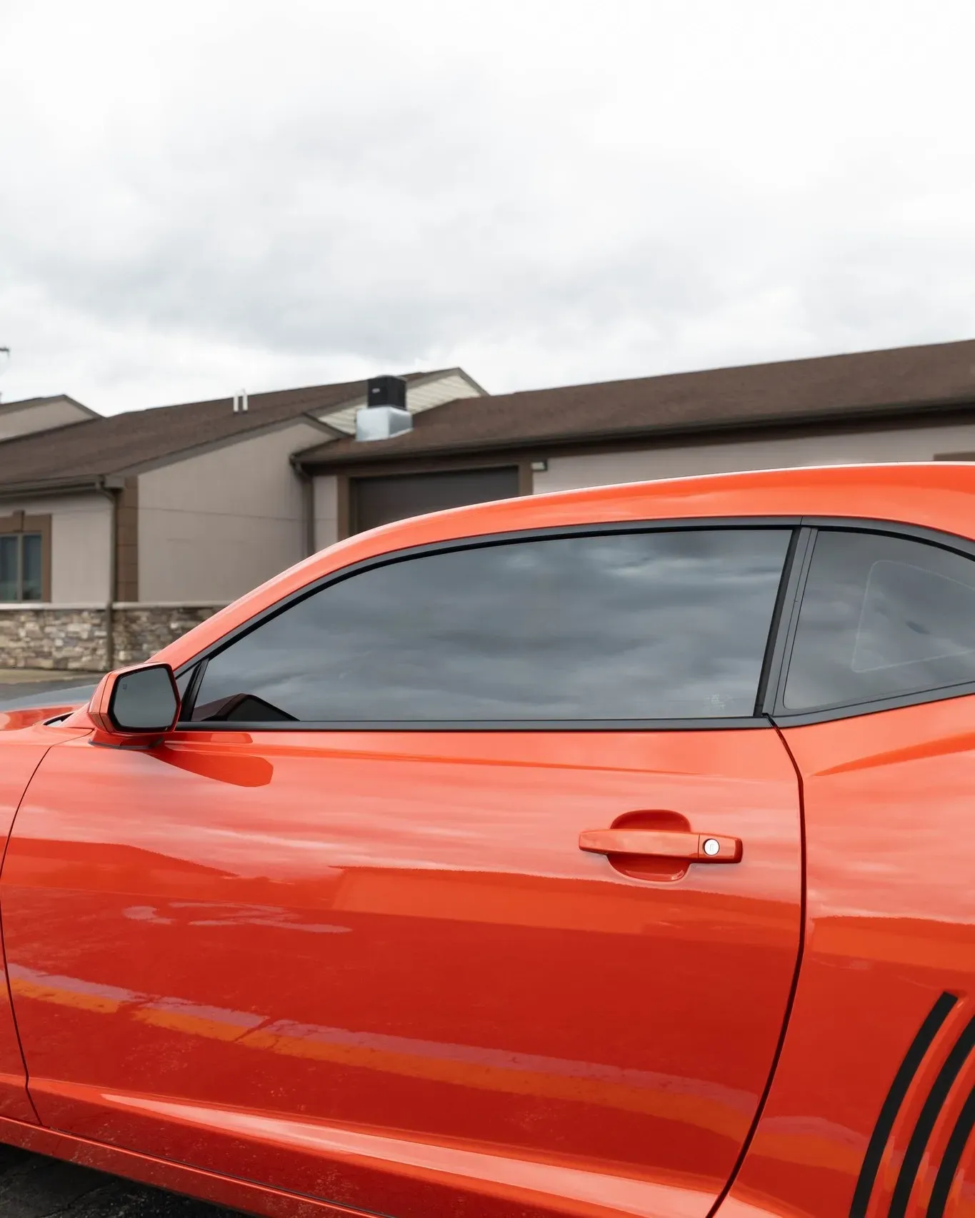 A red car is parked in front of a house.