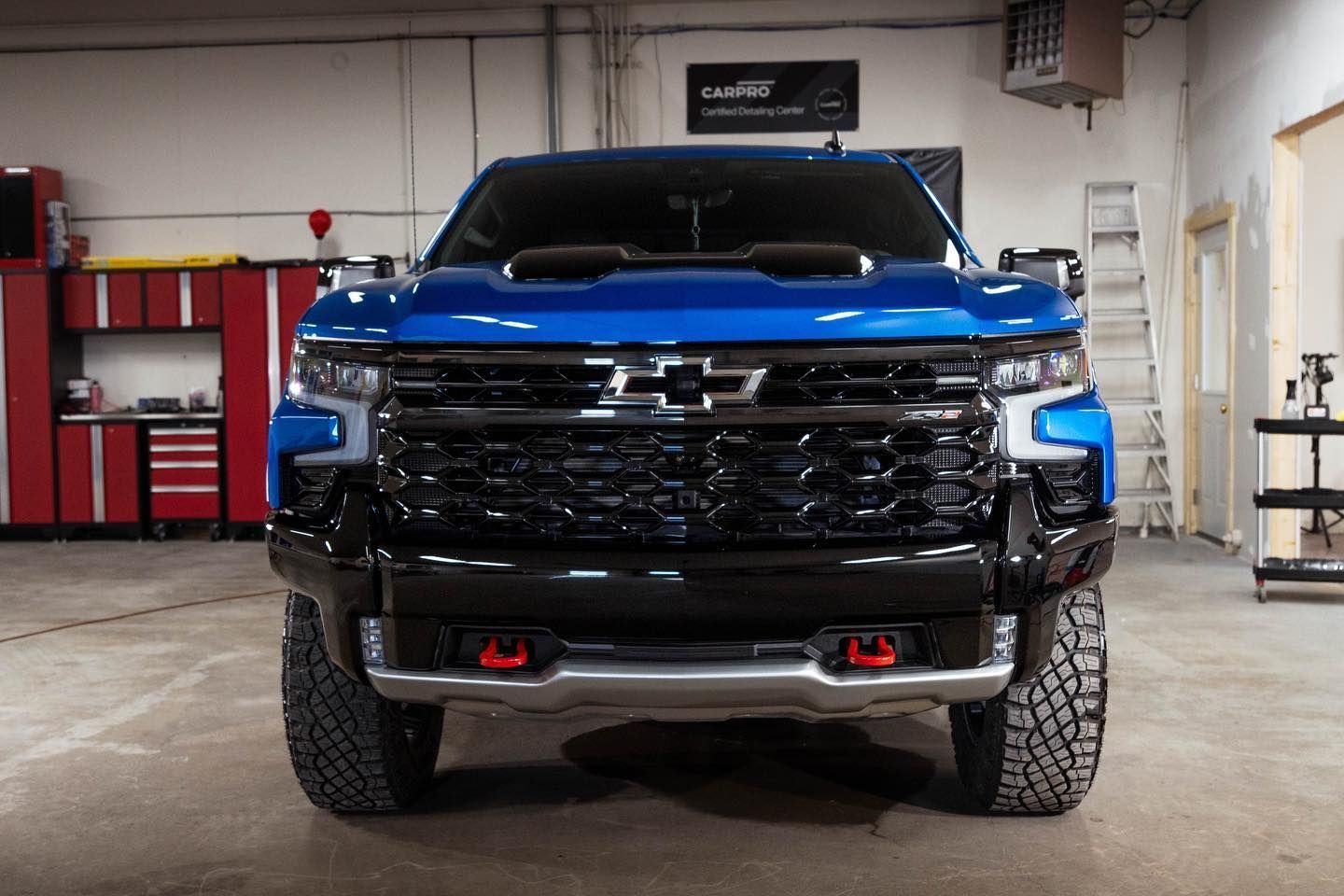 a blue chevrolet truck is parked in a garage .