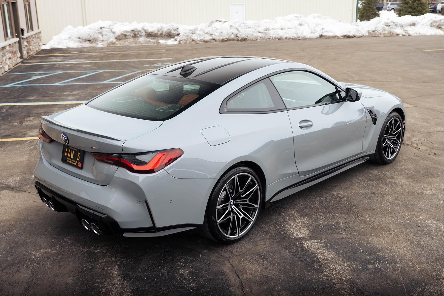 a gray bmw m4 coupe is parked in a parking lot .