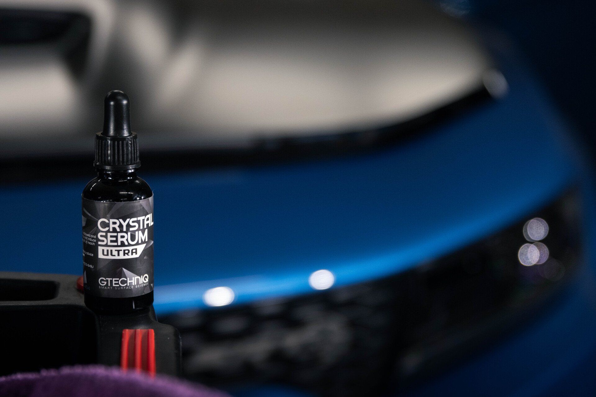 A person is applying protective film to the hood of a car.