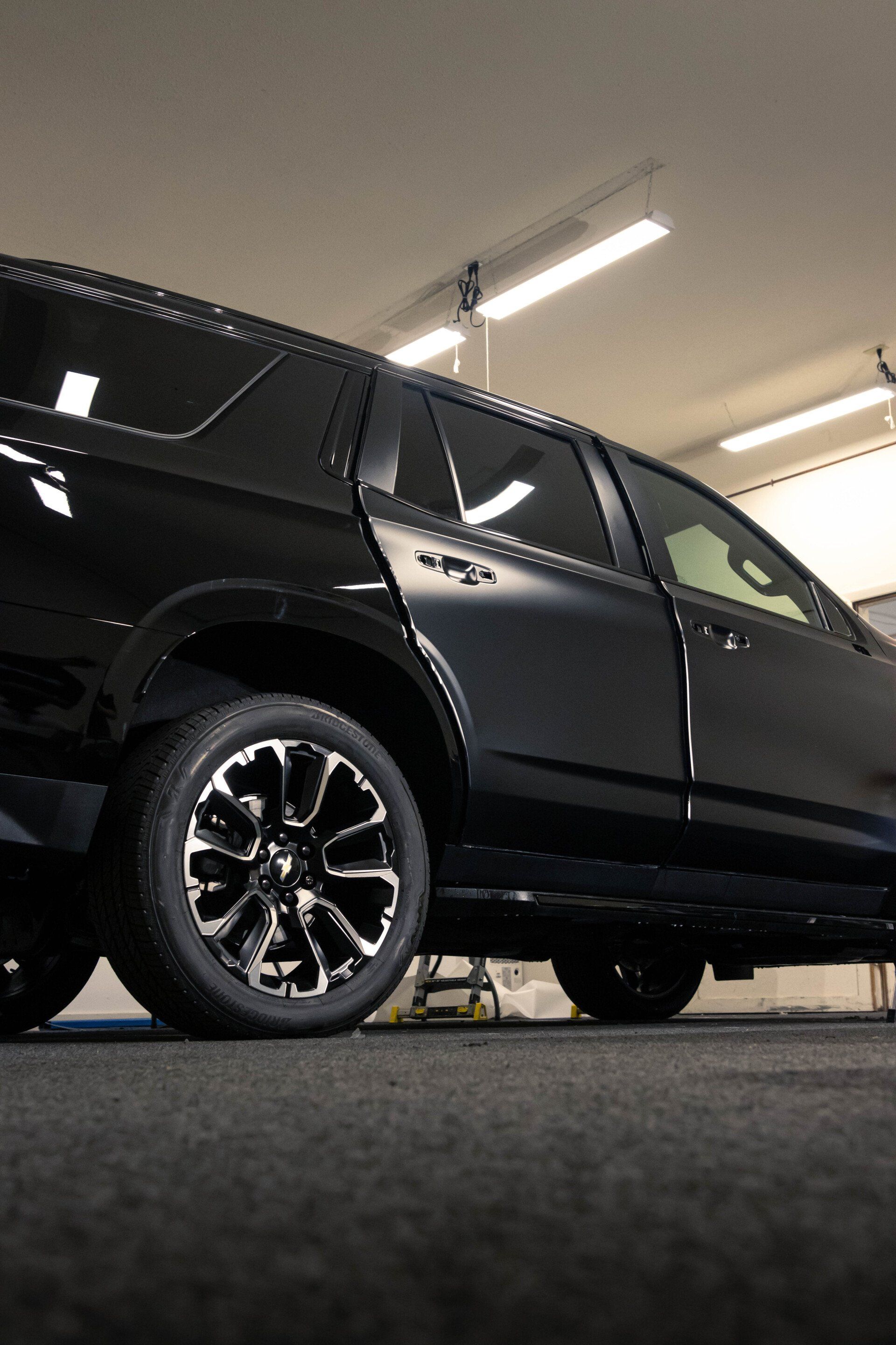 a black suv is parked in a garage with the door open