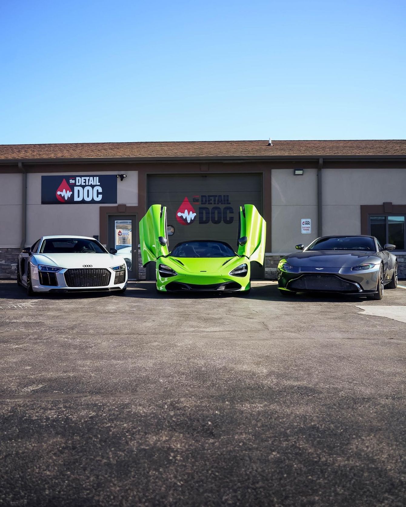 three sports cars are parked in front of a building that says detail dog
