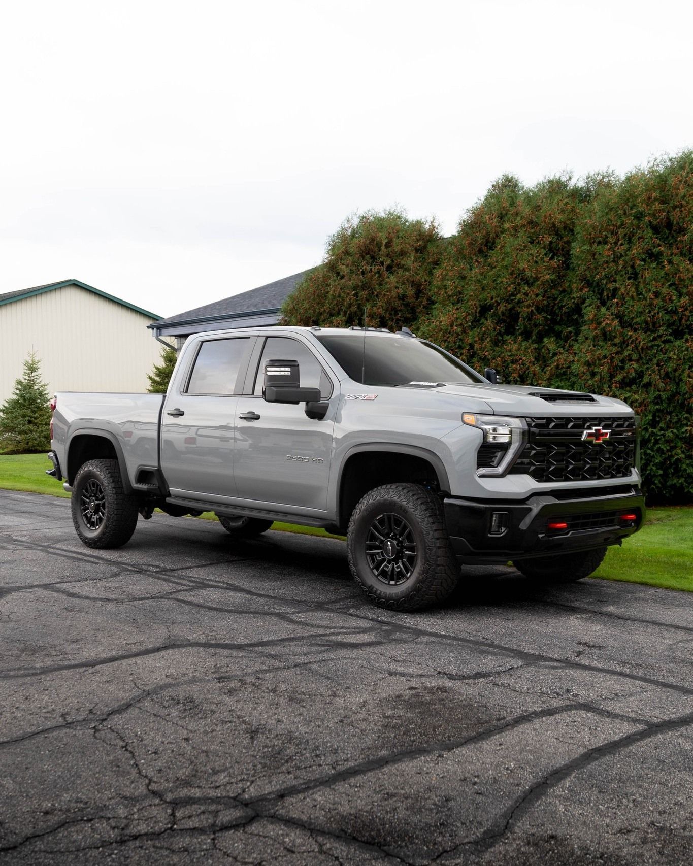 A silver pickup truck is parked on the side of a road.