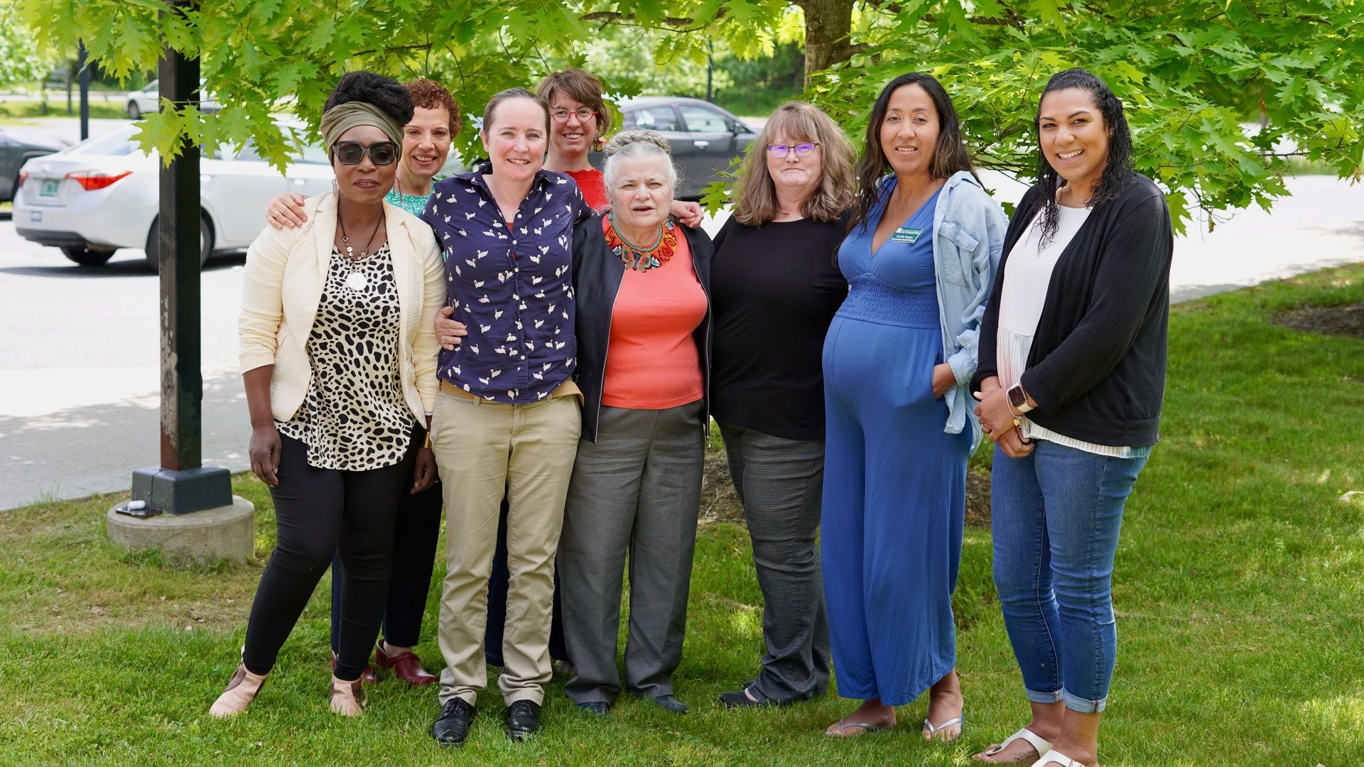 A group of women are posing for a picture in a park