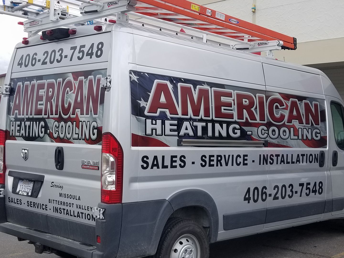 An american heating and cooling van is parked in a parking lot