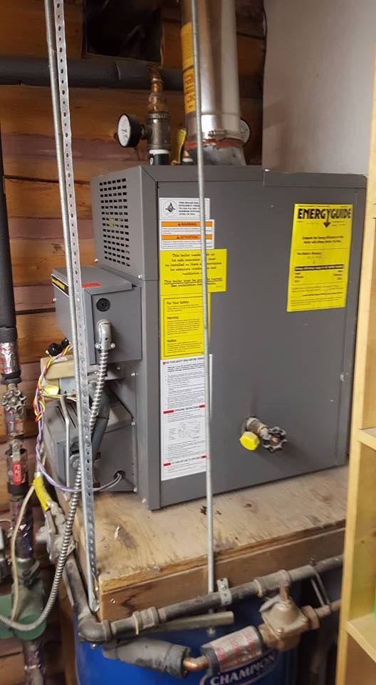 A water heater is sitting on top of a wooden table in a room.