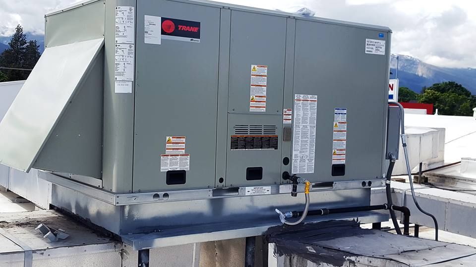 A large air conditioner is sitting on top of a roof.