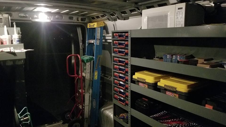 The inside of a van with shelves and a ladder.