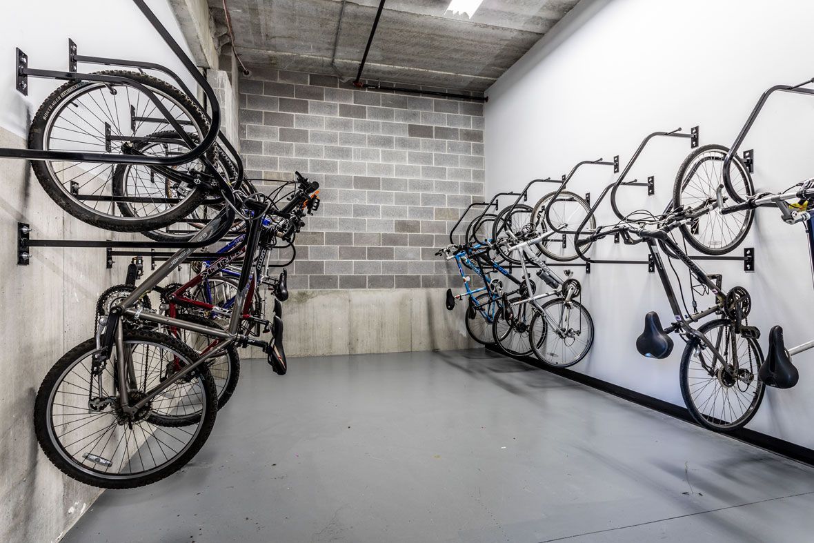 Here at Vim + Vigor Lofts in Wisconsin. A secure bike storage room features wall-mounted racks, concrete accents, and a clean, convenient space for resident bicycles.