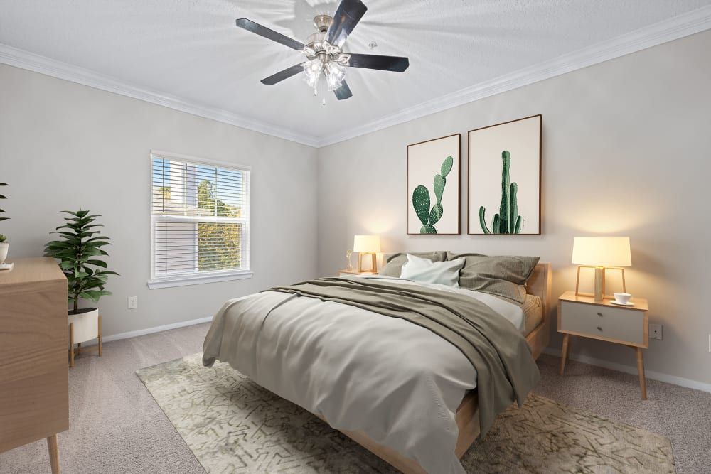 Apartment bedroom with a bed, dresser, nightstand, window, and ceiling fan at Marquis at Silverton in Cary, NC.