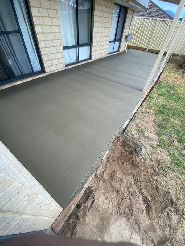Construction worker using a jackhammer to break concrete. Grey concrete and bucket, yellow generator.