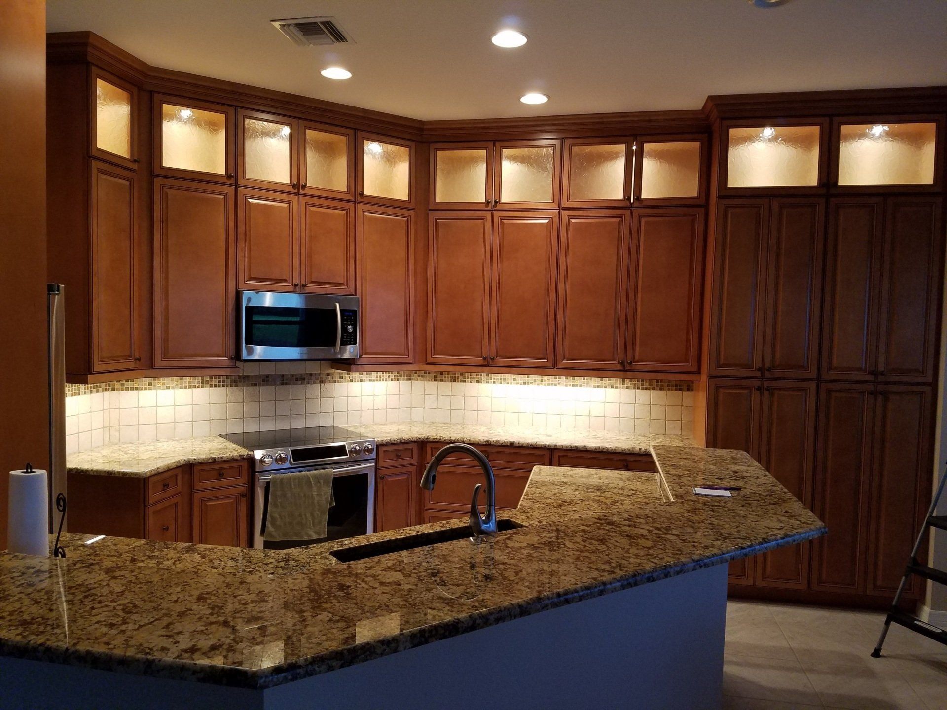 Kitchen with dark brown cabinets, granite countertops, stainless steel appliances.