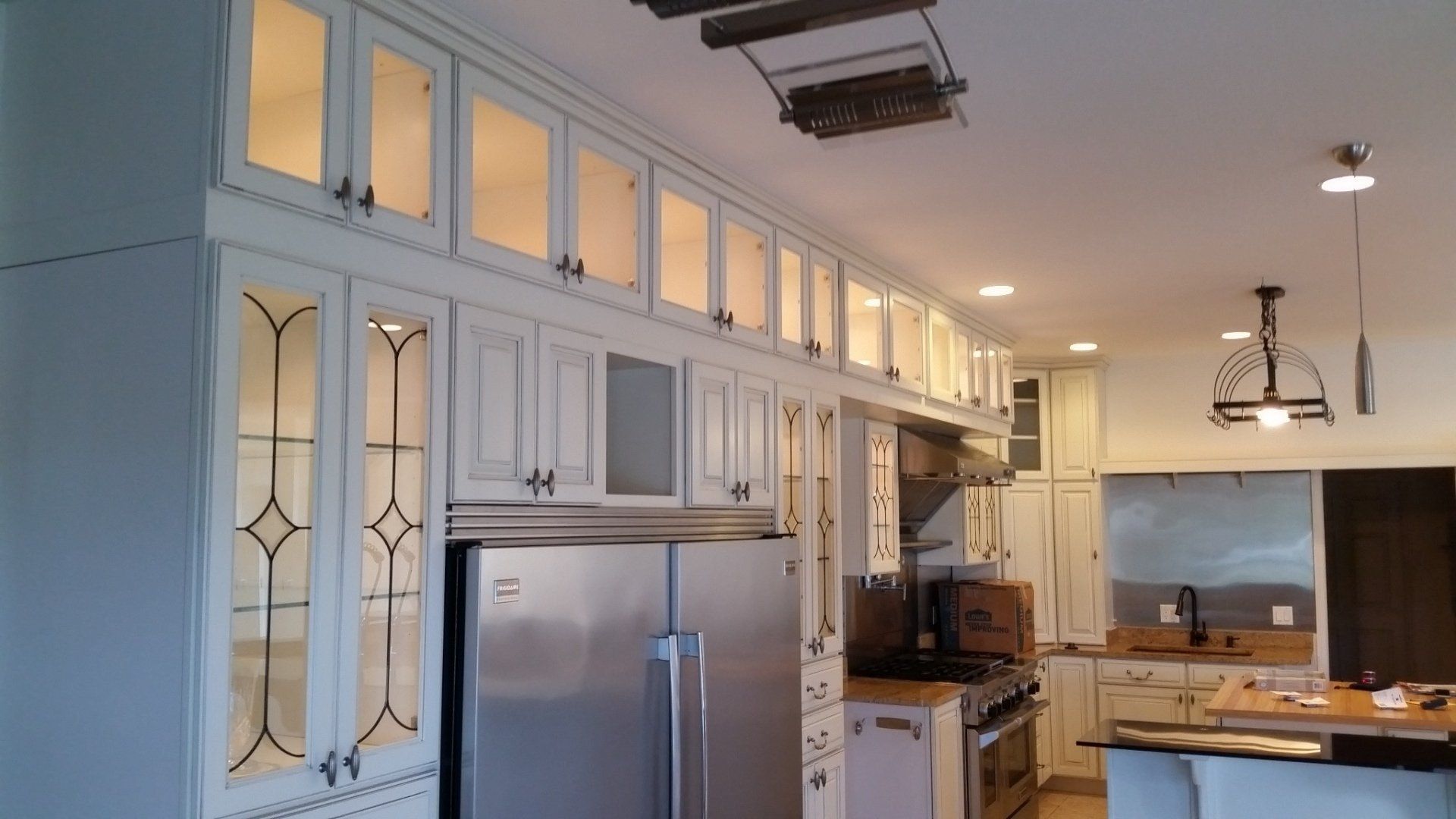 Kitchen with white cabinets, stainless steel appliances, and overhead lighting.