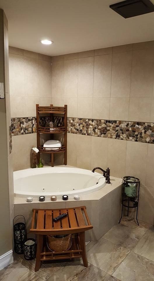 Cozy bathroom with a jacuzzi tub, wooden shelving, and candle accents.