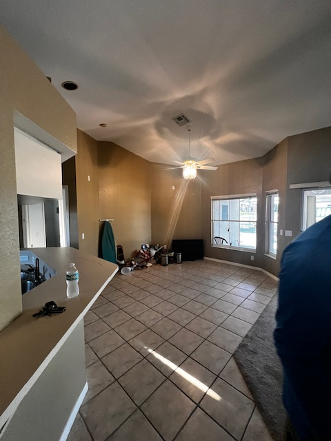 Kitchen with white cabinets, light blue walls, and a beige countertop.