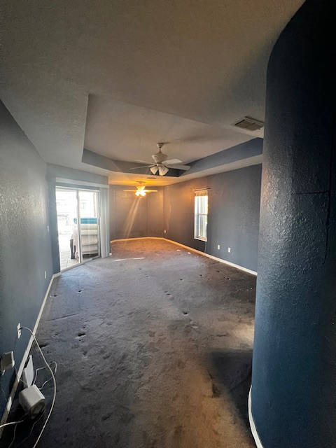 Empty room with built-in white bookshelves, brown blinds, and a pendant light, with tile flooring.