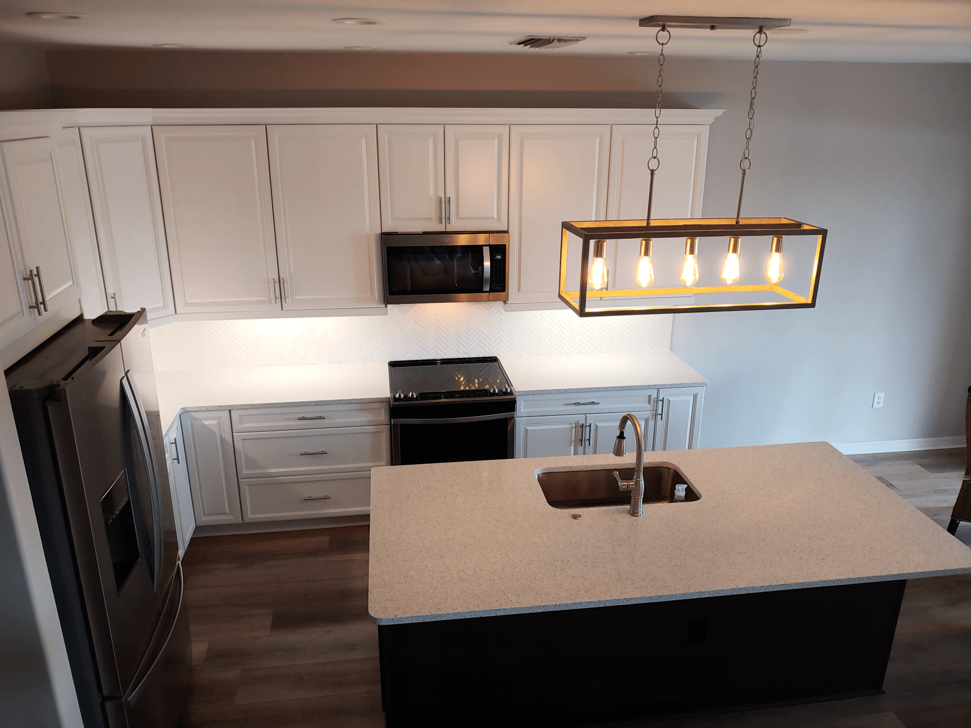 Modern kitchen with white cabinets, black appliances, and a kitchen island.