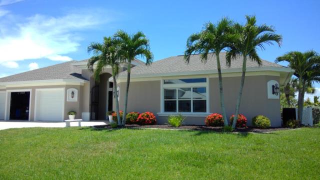 Tan house with palm trees, green lawn, and blue sky.
