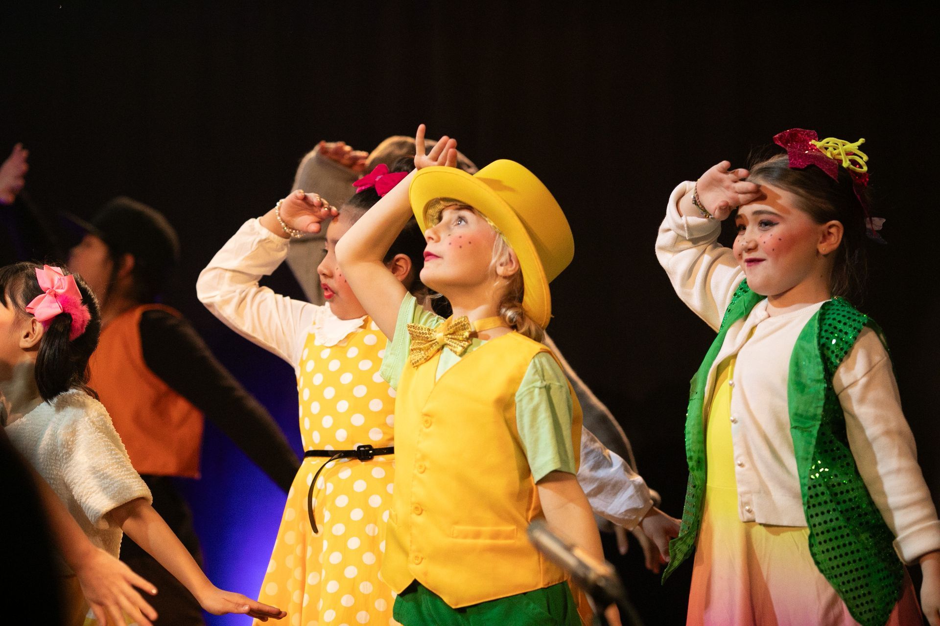 A group of young girls are dancing on a stage.