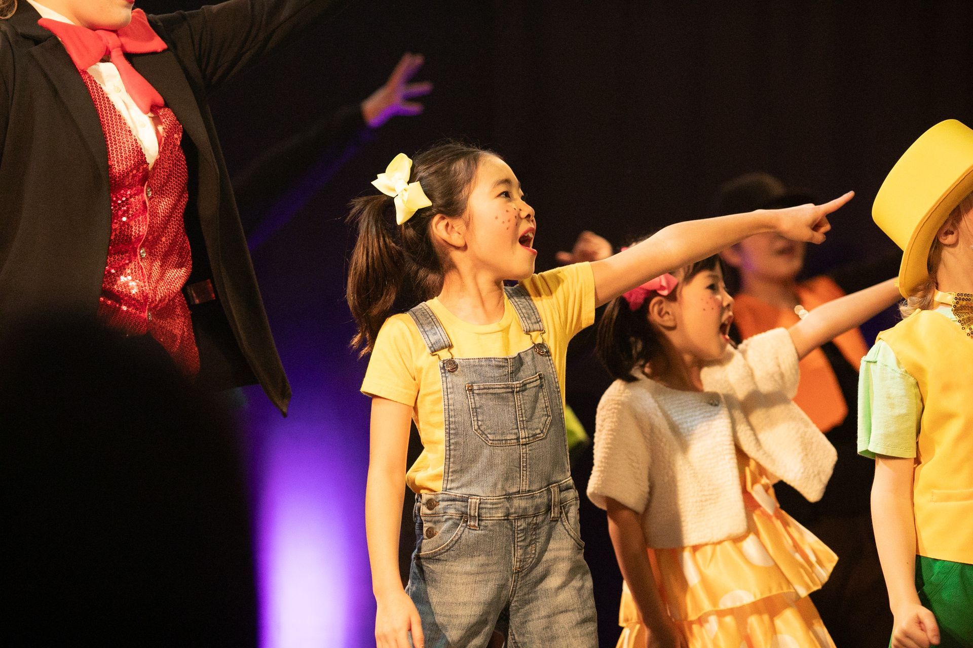 A group of young girls are dancing on a stage.