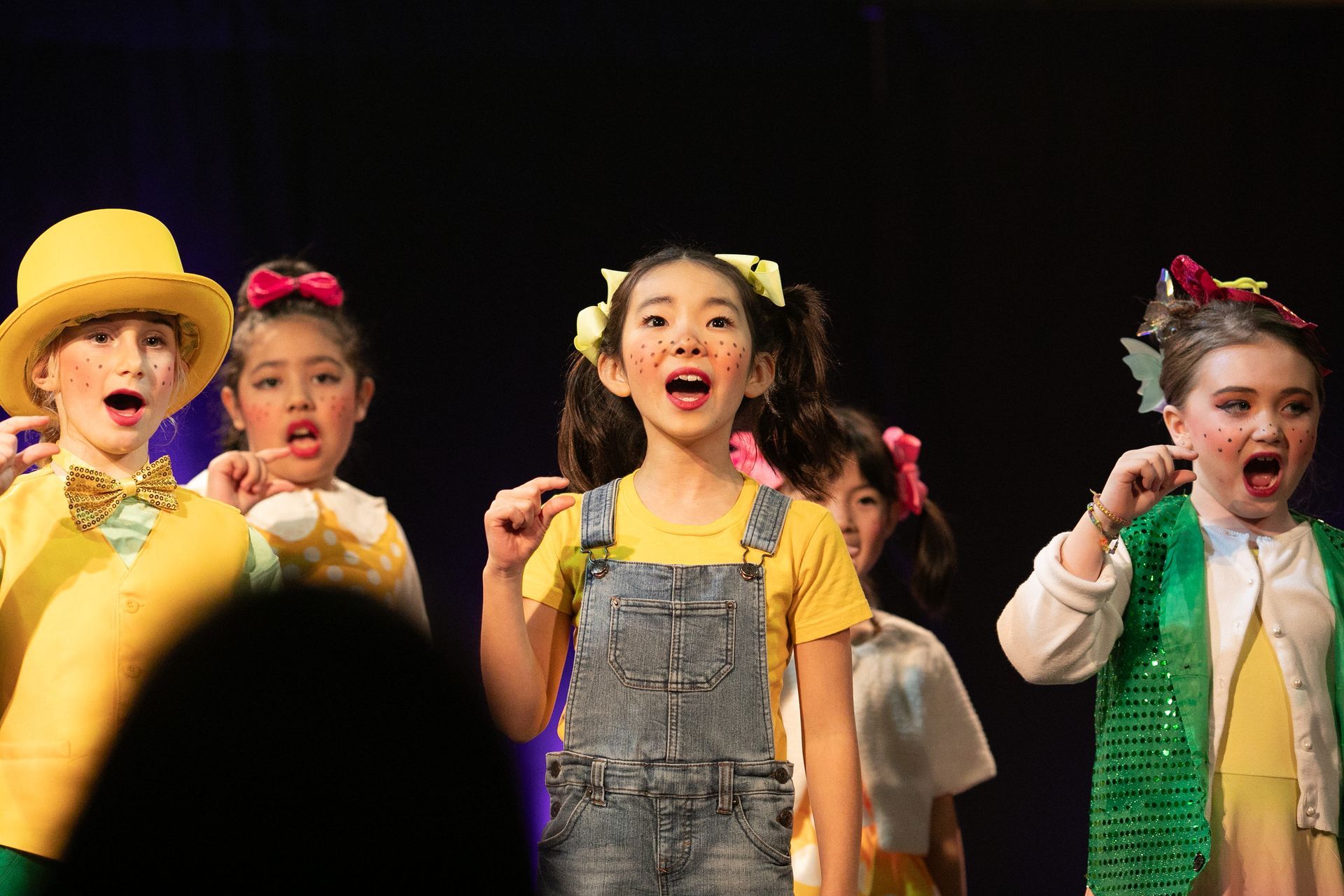 A group of children are singing on a stage.