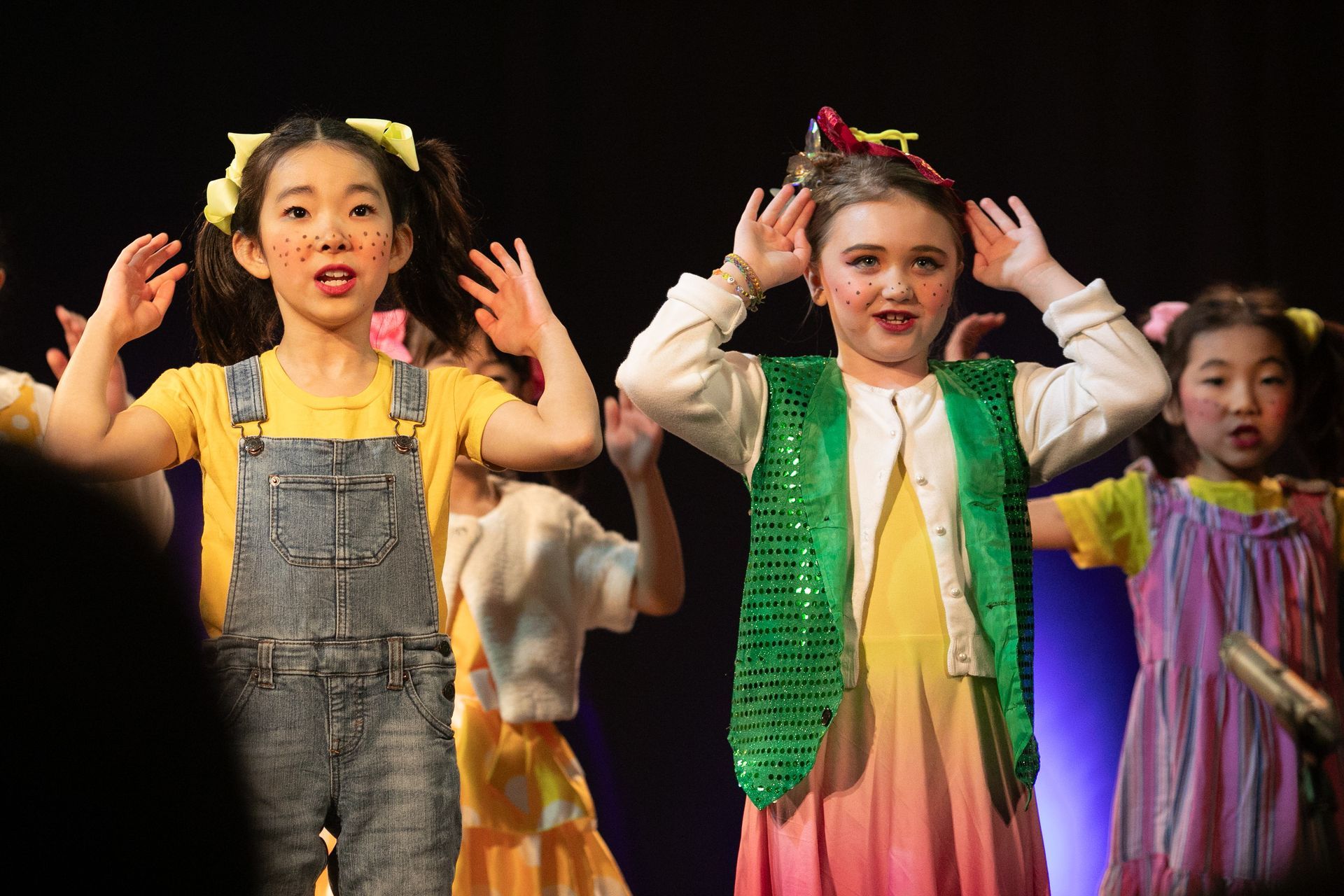 A group of young girls are dancing on a stage.