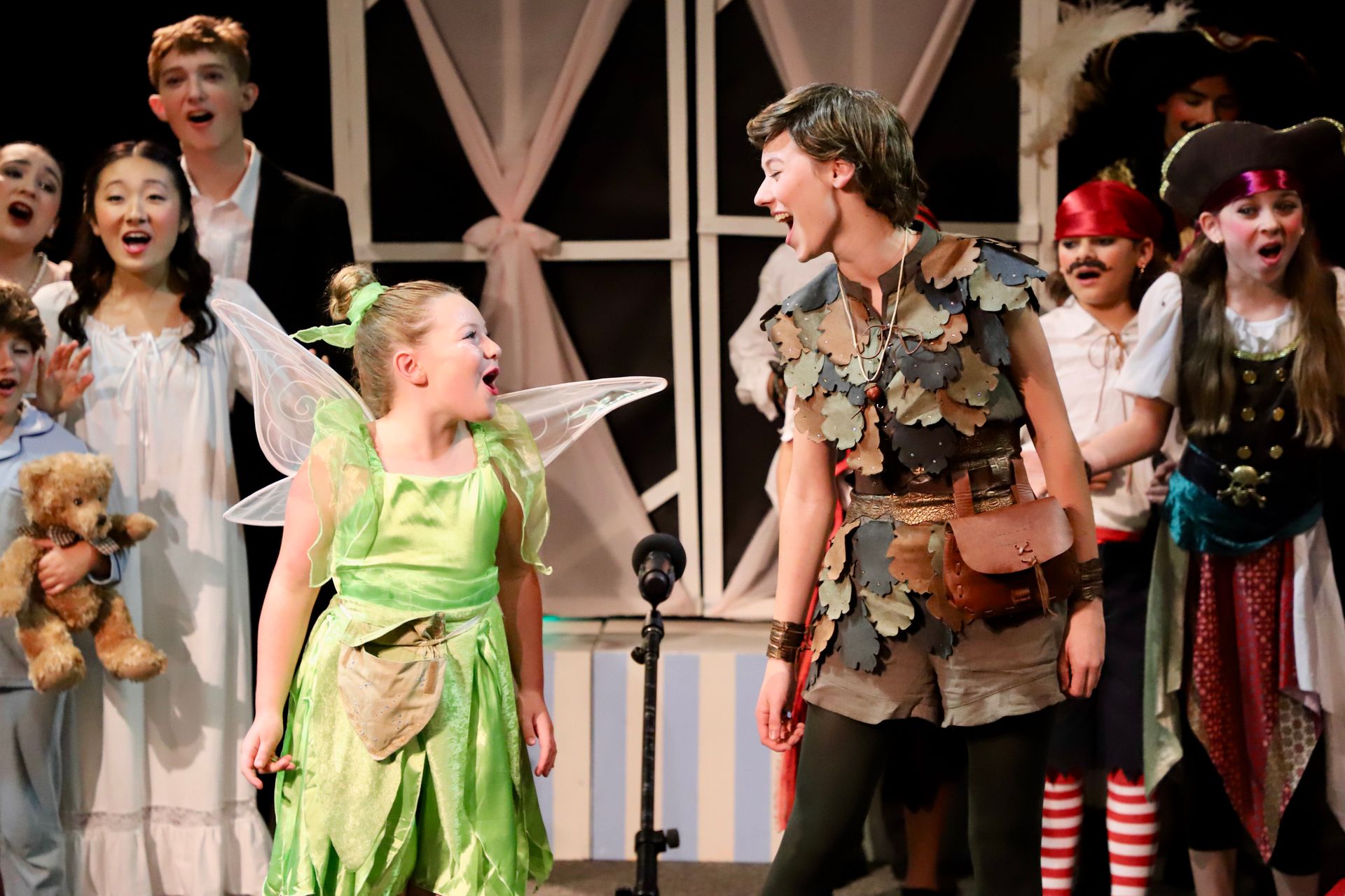 Peter Pan and Tinkerbell singing on stage in the Darling Nursery