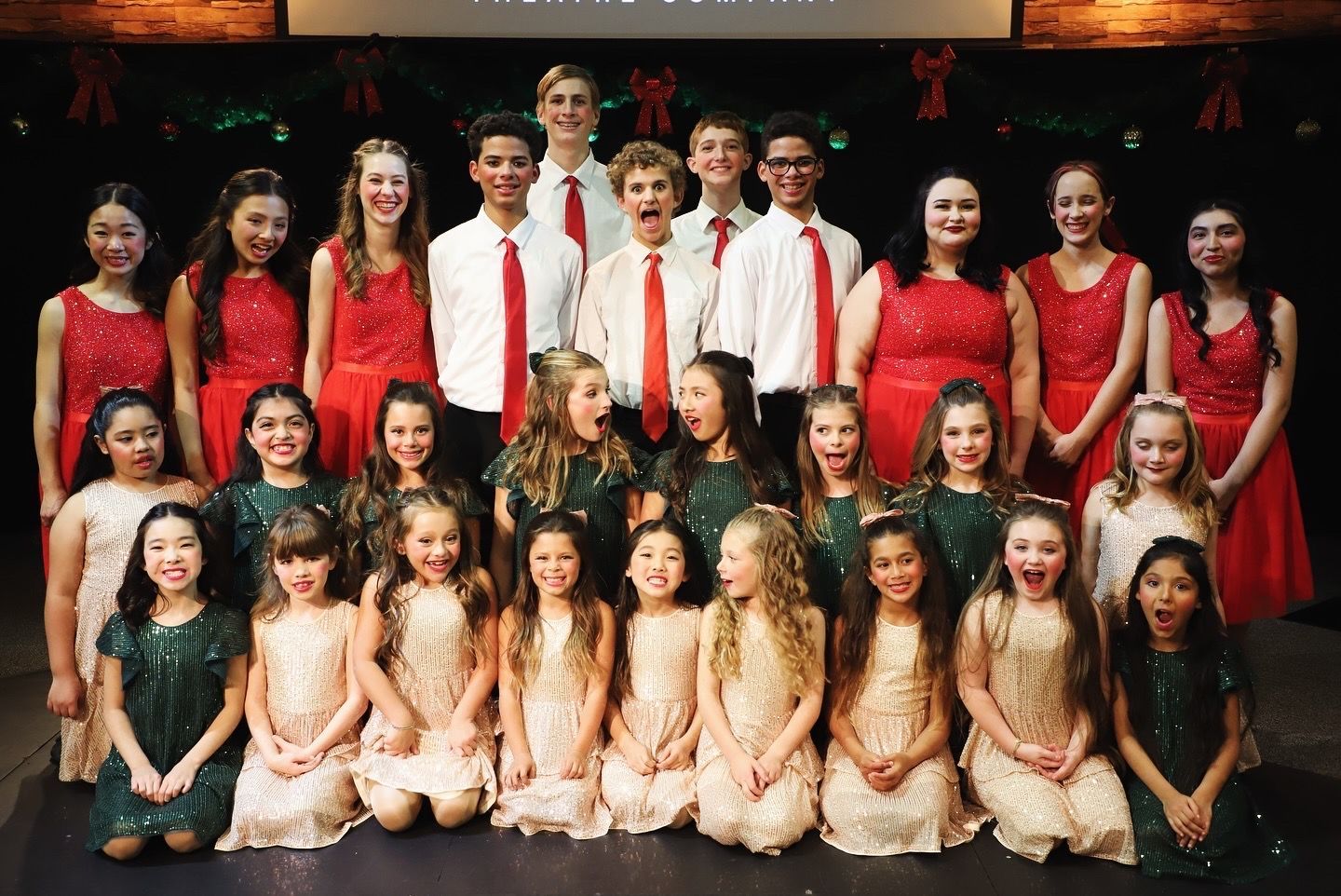 A group of children are posing for a picture on a stage.